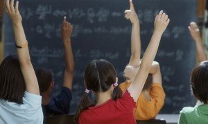 Rear view of class raising hands